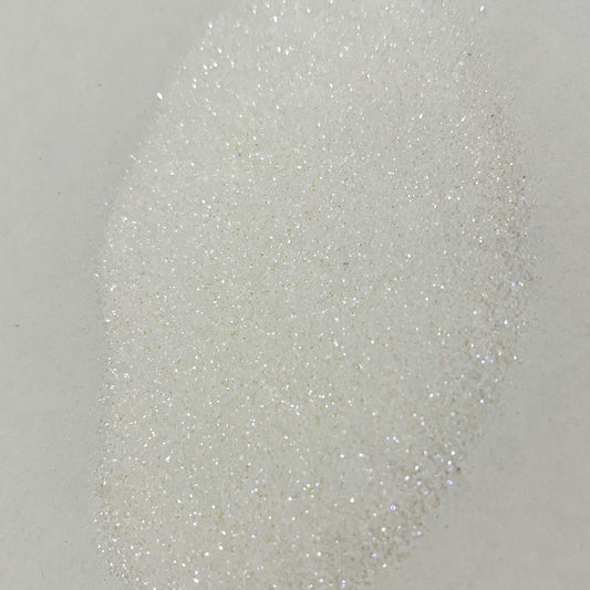 A close-up image of white polyester glitter with a sparkling appearance.