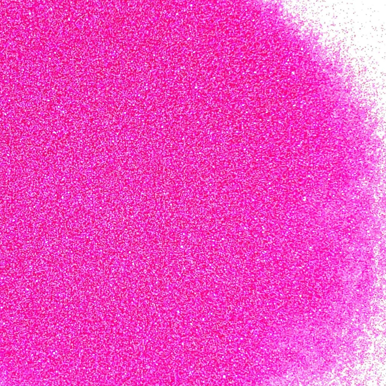 A pile of pink glitter, in extra fine on a white background.