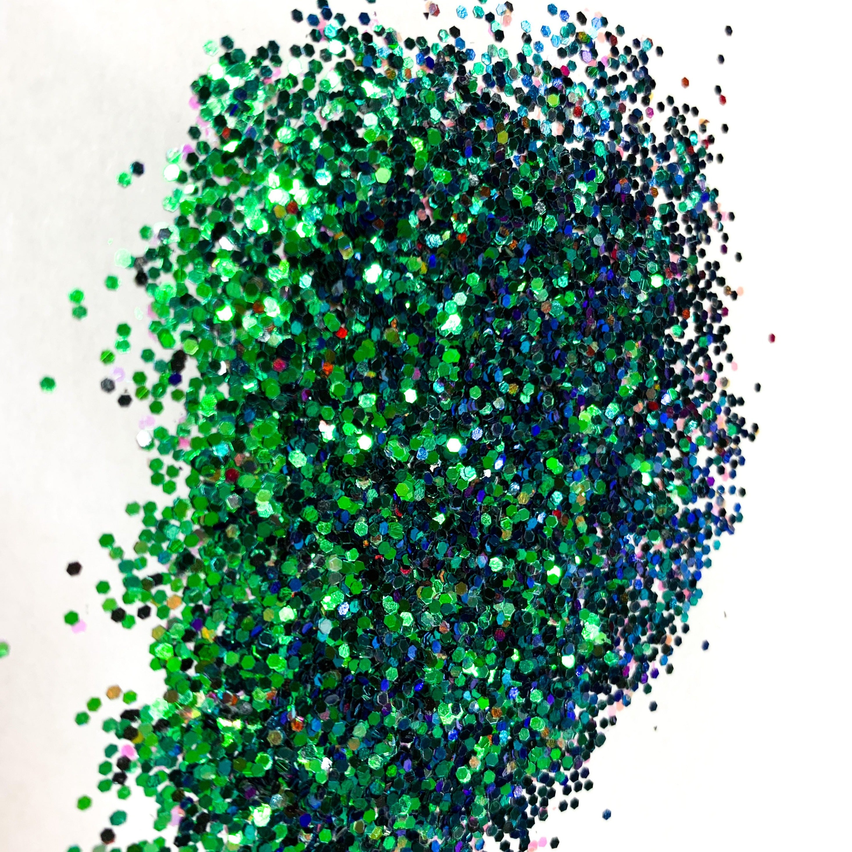 A blue/green chameleon colour shift glitter on a white background.