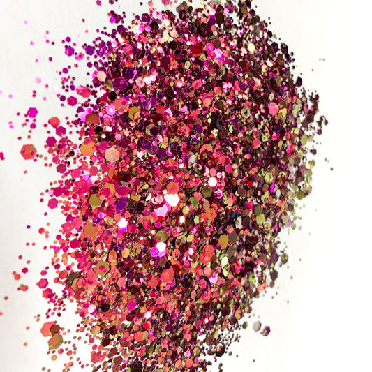 A pink/gold chameleon colour shift  glitter on a white background.