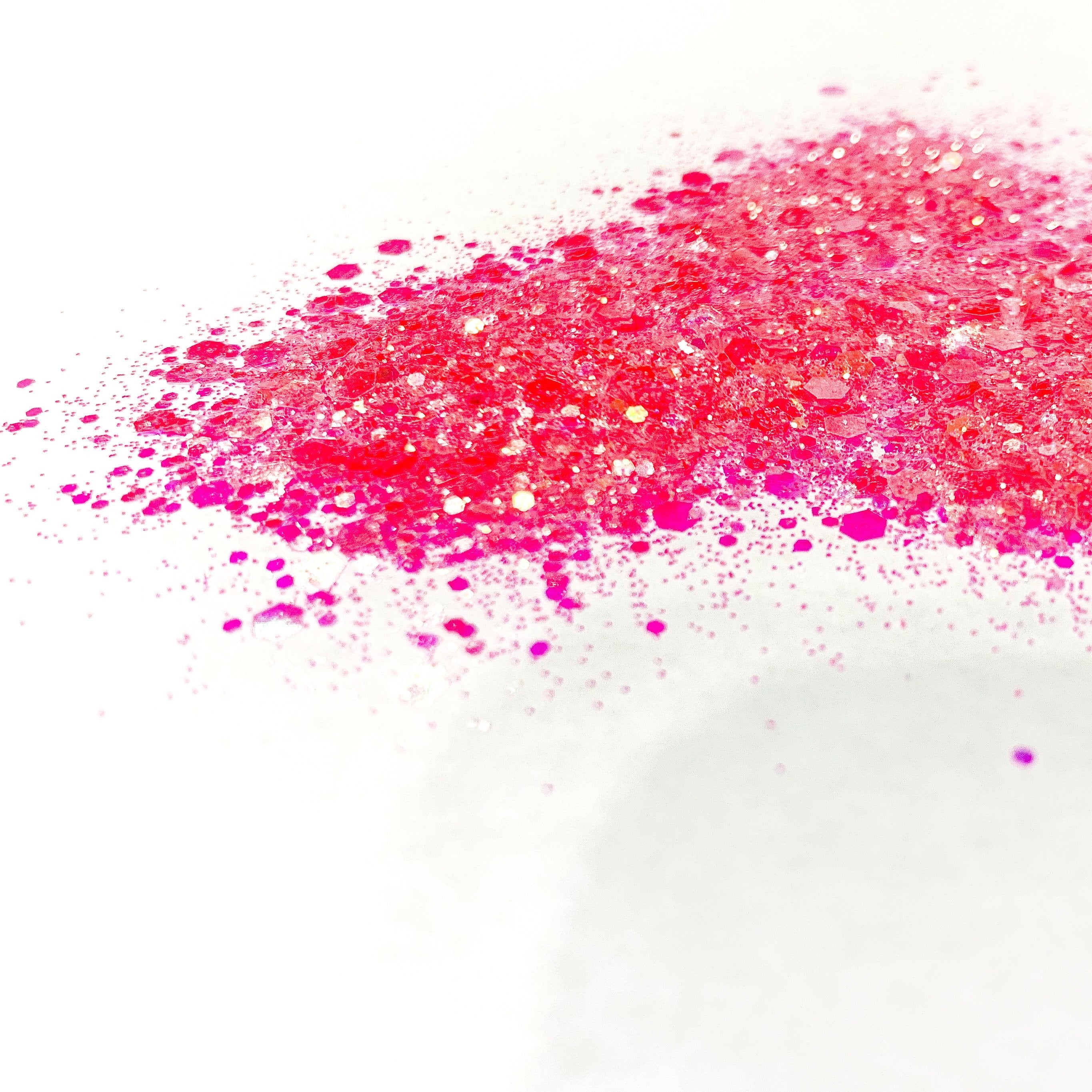 A pile of pink chunky glitter on a white background.