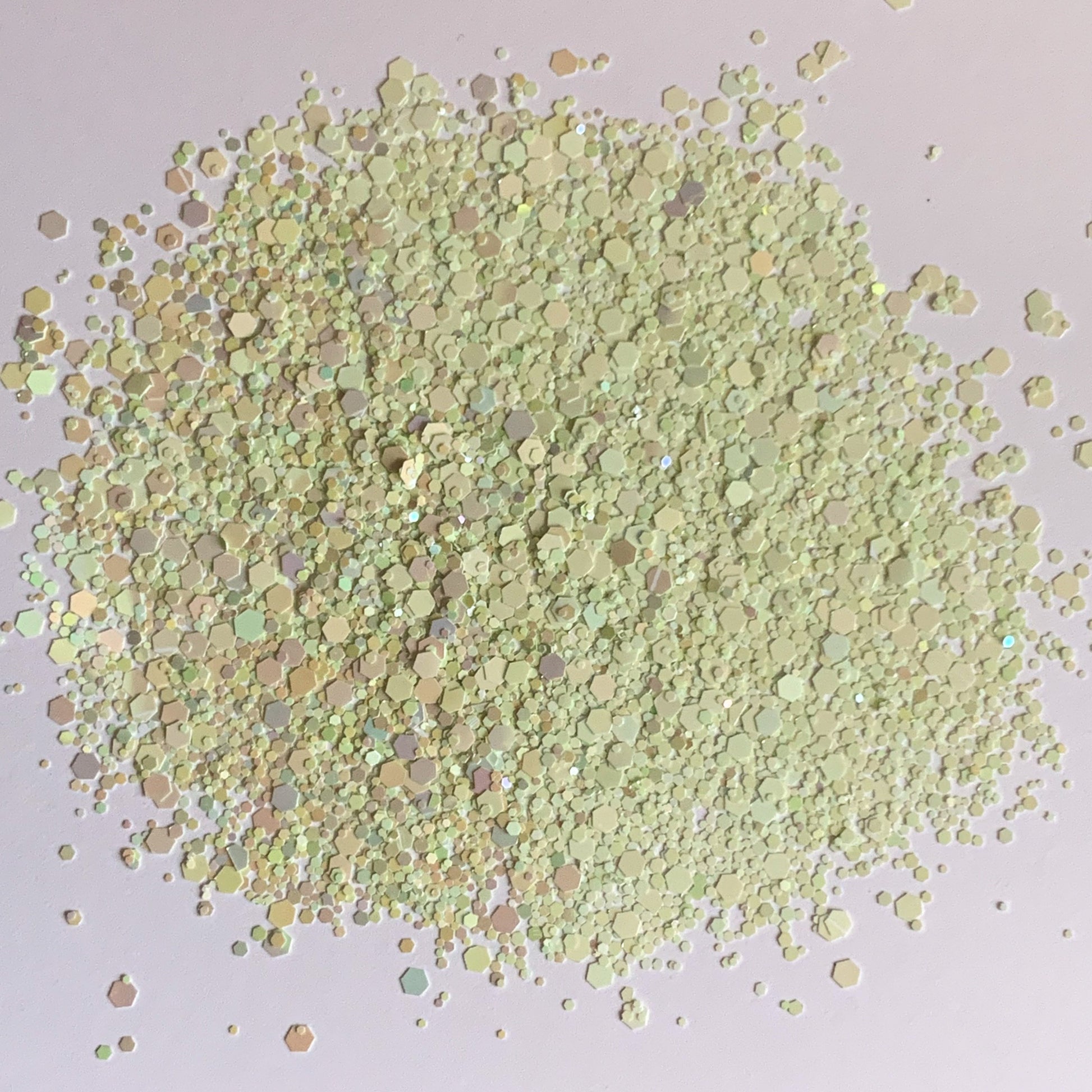 A pile of light green rainbow gradient chunky glitter mix.