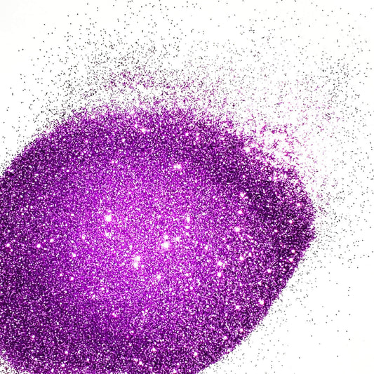 A close-up image of lilac purple colored polyester glitter spread on a surface.