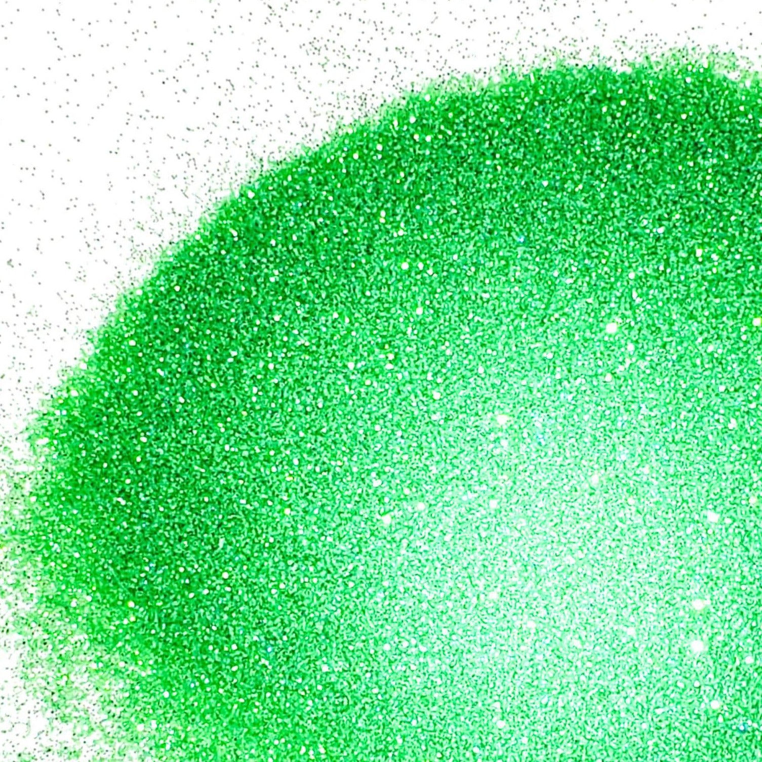 A close-up image of green colored polyester glitter spread out on a surface.
