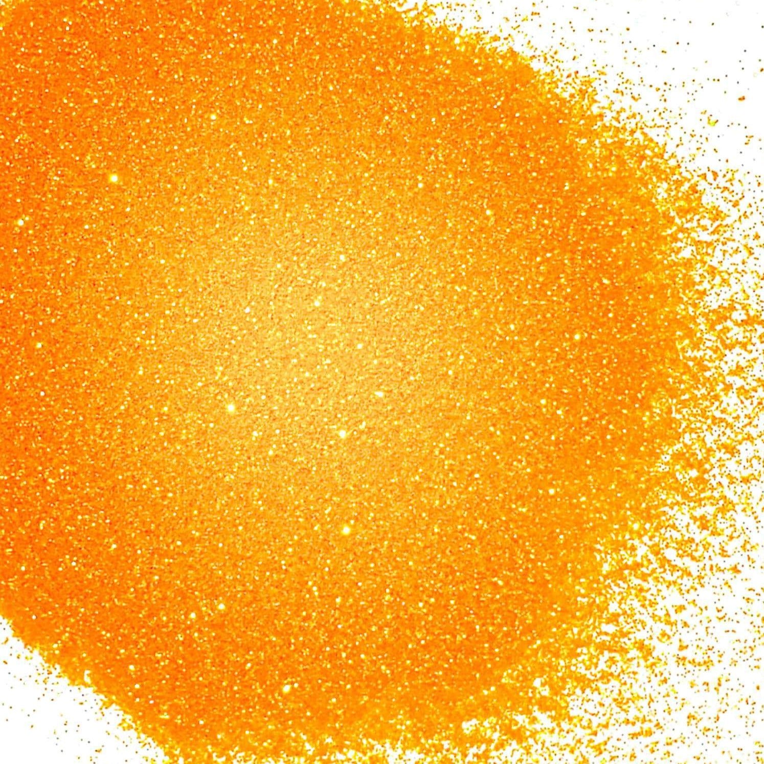 A close-up image of orange colored polyester glitter spread on a surface.