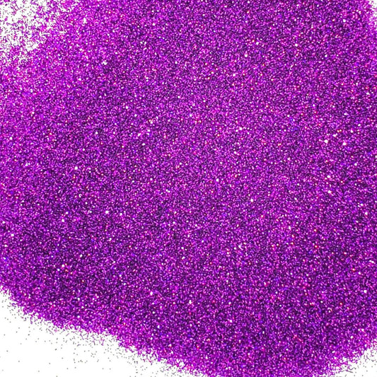 A pile of purple holographic glitter, in extra fine on a white background.