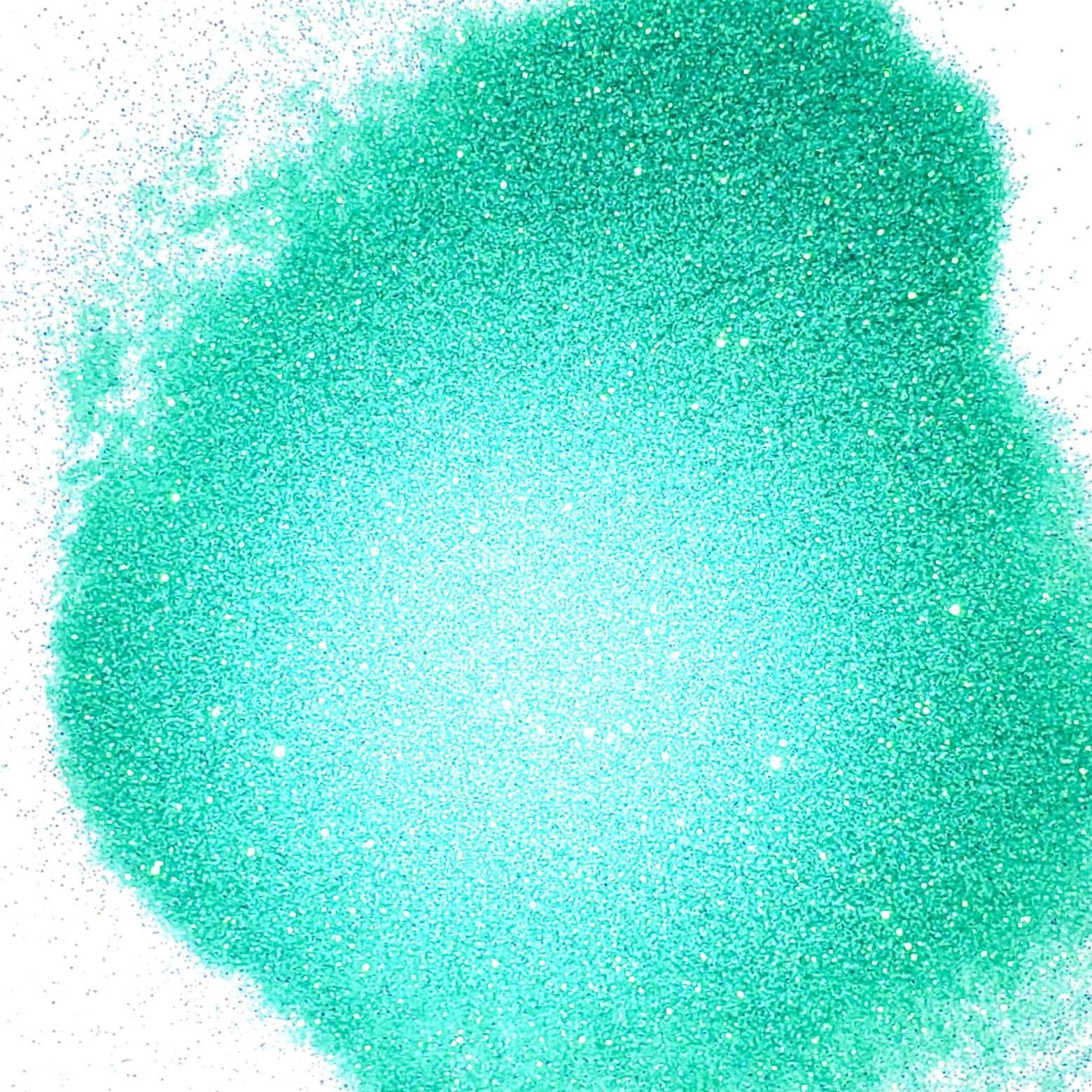 A pile of aqua glitter, in extra fine on a white background.