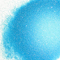 A close-up image of blue colored polyester glitter spread out on a surface.