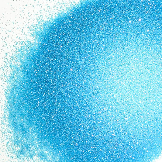 A close-up image of blue colored polyester glitter spread out on a surface.