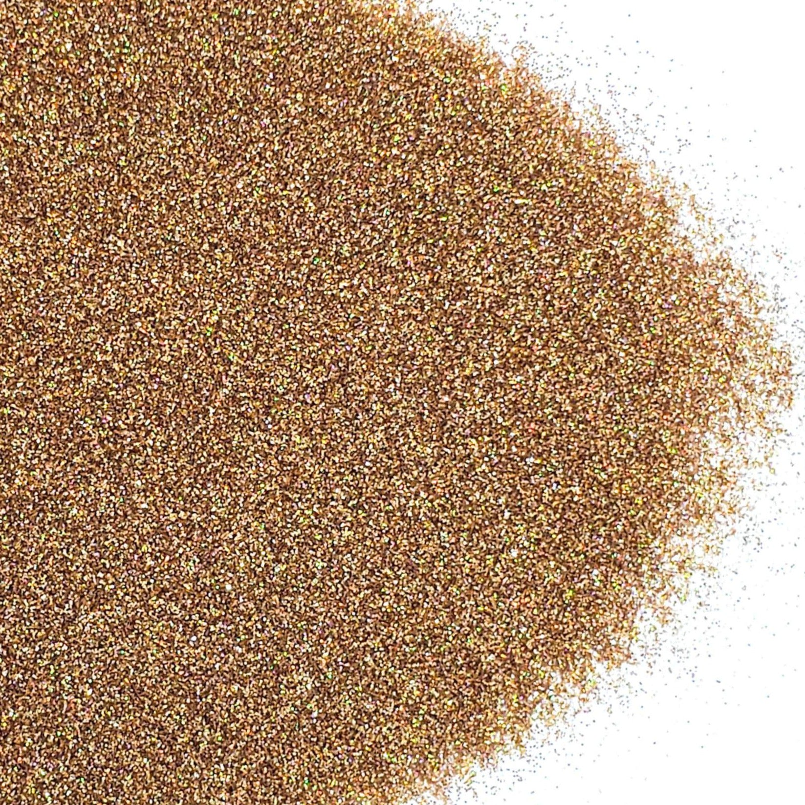 A pile of brown, extra fine holographic glitter spread on a white background.